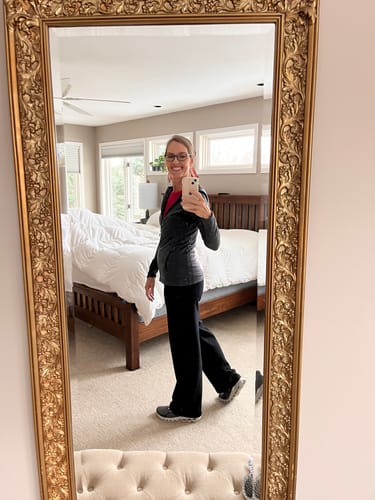 Reviewer in a mirror selfie showing the side view and fit of the black Ellie Wide Leg Pants.