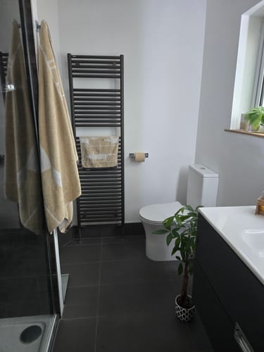 Customer's Unbleached Bamboo Toilet Paper roll on a holder in a clean, modern bathroom.