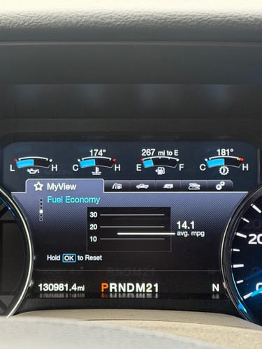Close-up of a truck's dashboard showing cooler temperatures after installing the SPE Low Temp Thermostat, with coolant at 174° and transmission at 181°.