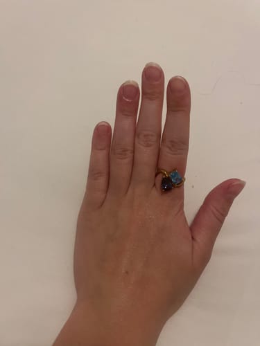 Reviewer's hand wearing the Navae Birthstone Ring, showing its two blue stones set on a gold band.