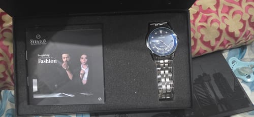 Customer's Modicci stainless steel watch with a dark blue dial, displayed inside its black presentation box.