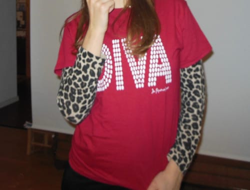 Reviewer wearing the red diva baby tee layered over a long-sleeve leopard print shirt.
