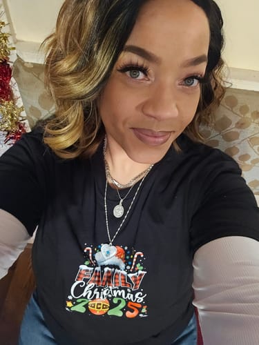 Reviewer wearing the Zury Sis Sassy wig styled in soft waves with blonde highlights.