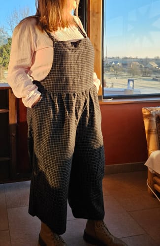 Cliente portant la salopette Isaure en flanelle tartan, montrant la coupe ample et le tombé du tissu.