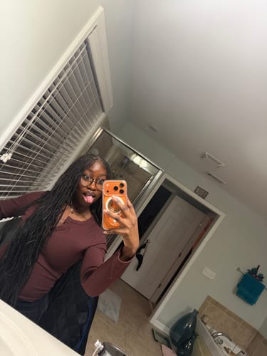 Customer selfie showing their long Body Wave Bulk Hair Extensions styled in braids in a bathroom mirror.