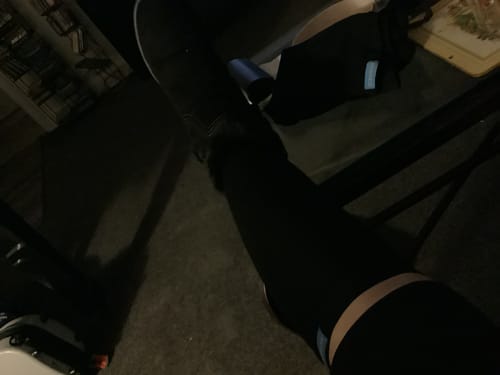 Partial view of a customer wearing black Performance Eucalyptus Compression Socks in a dark room.