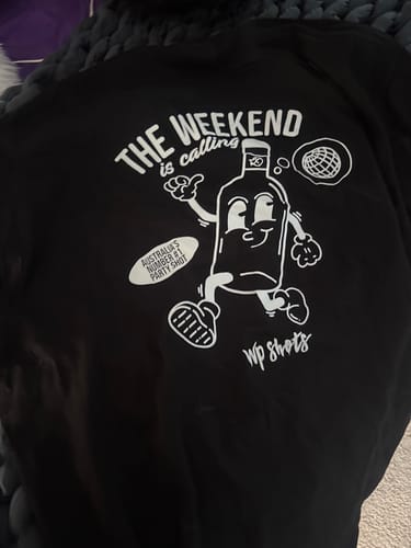 Reviewer showing the back of the black Sour Puss Weekend T-Shirt with its funny cartoon graphic.
