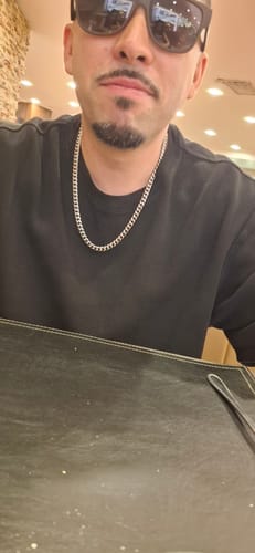 Un cliente usando la Cadena Cuban Link de 8mm sobre una camiseta negra.