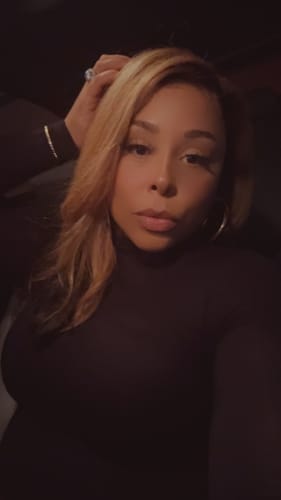 Reviewer wearing the black NW Sculpt Mock Neck Bodysuit in a dark, moody setting.