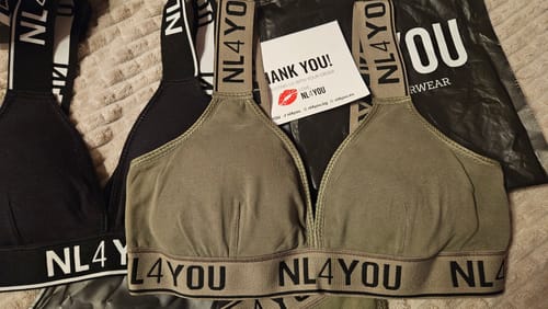 Customer's khaki green cotton bralette and a black one laid out with NL4YOU packaging.
