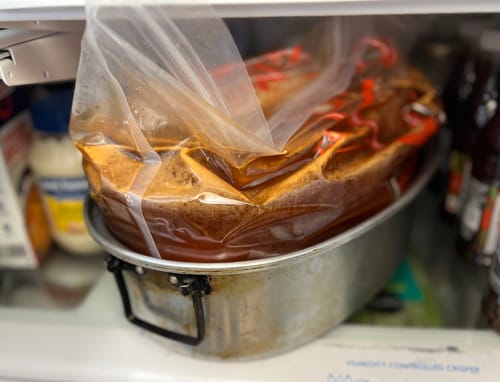 Customer's turkey soaking in a brining bag filled with Turkey Brine, placed in a roasting pan in the fridge.