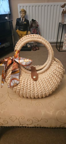 Reviewer's completed Shell crochet Handbag in beige, featuring circular handles and a stylish patterned scarf.