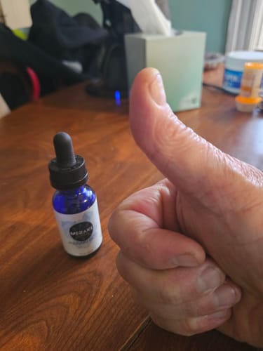 Reviewer gives a thumbs up next to the Meraki Blu Methylene Blue bottle on a wooden table.