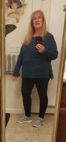 Reviewer showing the relaxed fit of the blue Ainsley Sweater with side slits in a mirror selfie.