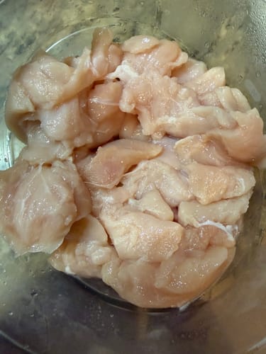Reviewer's raw Halal Portioned Chicken Breast, sliced and ready for cooking in a clear bowl.