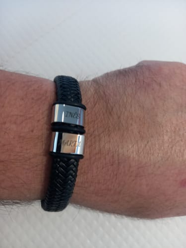 Customer wearing the black braided Viking bracelet with two personalized silver beads on their wrist.
