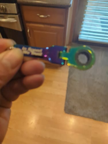 Close-up of a customer holding the iridescent 10mm Wrench Keychain in their hand.