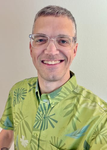 Reviewer smiling in a close-up shot of the light green, floral Zootopia 'The Wilde Side' shirt.