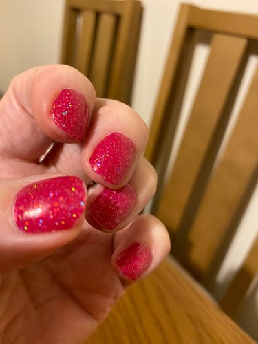 Close-up of a customer's nails wearing the sparkly Raspberry Sparkle gels.