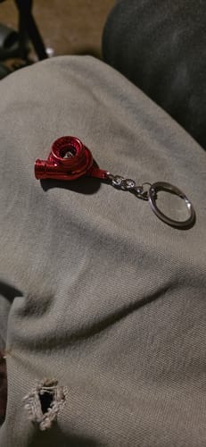 A customer's red Turbo Keychain resting on their lap.
