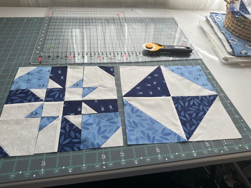 Reviewer's quilting project with the Stripology XL Ruler and cut blue and white fabric blocks on a mat.