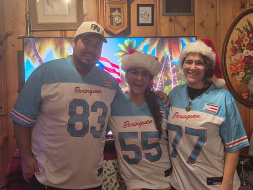 Customer and two family members posing in their matching light blue and white 'Borinquen' jerseys for Christmas.