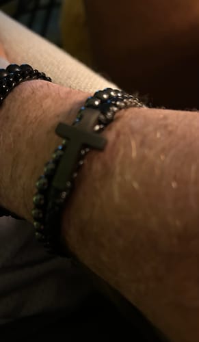 Close-up of a customer wearing the black FIDES Cross leather and bead bracelet on their wrist.