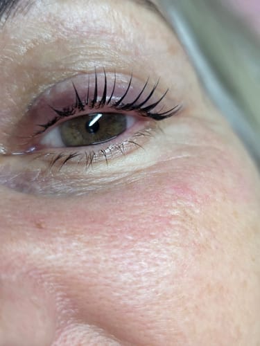Close-up of a reviewer's eye showing long, dark lashes after a lash lift using the Cysteamine lamination kit.