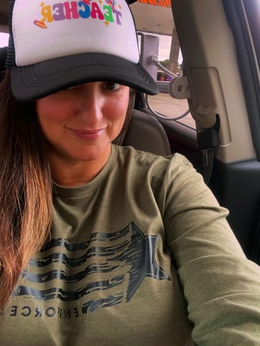 Customer taking a selfie in a car wearing the green Blessed Long Sleeve shirt.