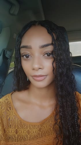 Customer showing her bohemian knotless braids styled with the long, dark Double Drawn Burmese Deep Wave hair.