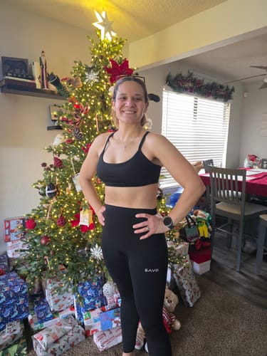 Reviewer smiling while wearing the black Essential Seamless Leggings with a high waist in a home setting.
