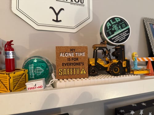 Reviewer's can of Tropical Fruit Nicotine Pouches displayed on a small toy forklift on a shelf.