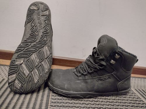 Asiakkaan mustat Vaistoa Uoma 3 Talvi -kengät, joista toisessa näkyy pohjan kuviointi.