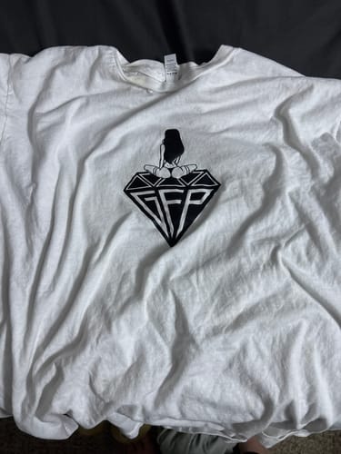 Customer's white MEMBERS TEE laid out, showing a black graphic of a woman sitting on a diamond with the letters 'SFP'.
