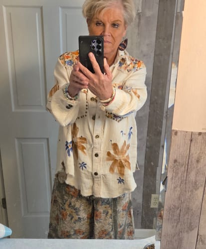 Reviewer wearing the lightweight shacket with floral print and stud embellishments.