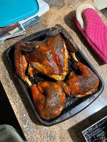 Customer's spatchcocked turkey with dark, seasoned skin in a roasting pan, cooked using the Turkey Brine Kit.