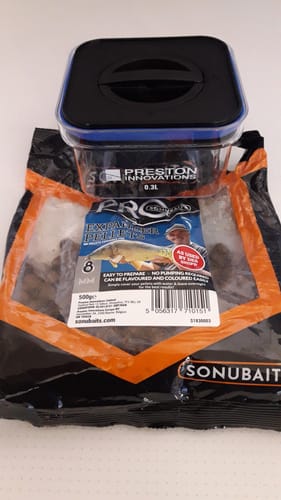 Recensents Bait Safe Container, getoond met een zak expander-pellets voor het vissen.