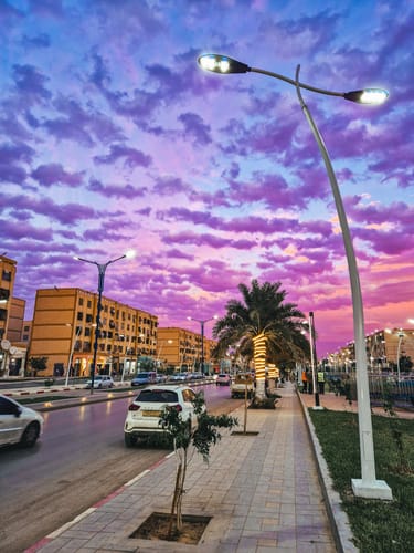 Customer's photo of a city street edited with FILM II LIGHTROOM PRESETS, showing a vibrant purple sky over buildings at dusk.