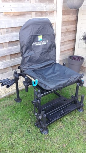 Klant toont de zwarte waterdichte cover op een Absolute 36 Feeder Chair, buiten op het gras.