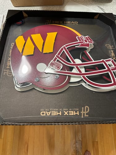 Customer's Washington Commanders helmet metal wall art shown inside its original packaging.