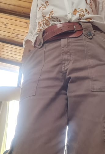 Una clienta muestra un primer plano de sus jeans cargo Juana de color café.