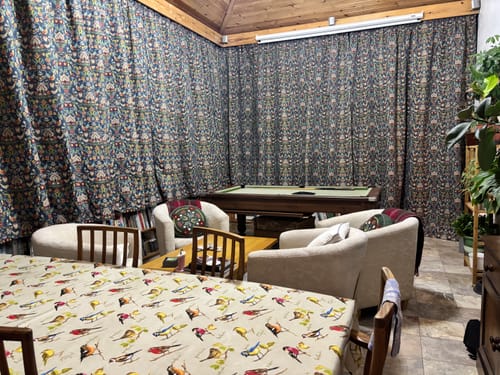 Customer's room showing the Birds and Flowers Tapestry Fabric used as long, dark curtains covering multiple walls.