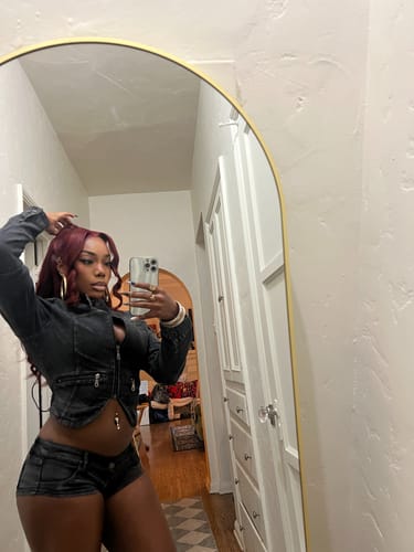 Customer posing in a mirror wearing the black denim MICRO MINI SHORTS with a matching jacket.