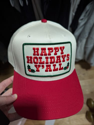 Reviewer holding the red and off-white Happy Holidays Y'all Two Tone Hat.