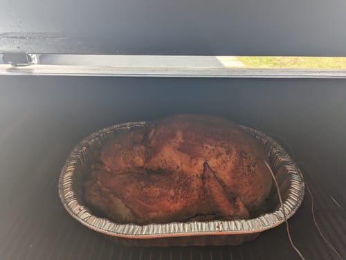 Customer's large, roasted turkey made with the Turkey Brine, cooking in a smoker.