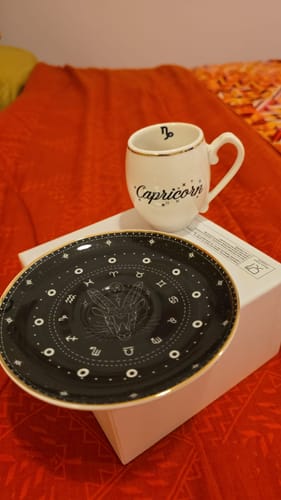 Customer's Karaca Capricorn Coffee Cup and saucer set, showing the white cup and the black saucer with zodiac designs.