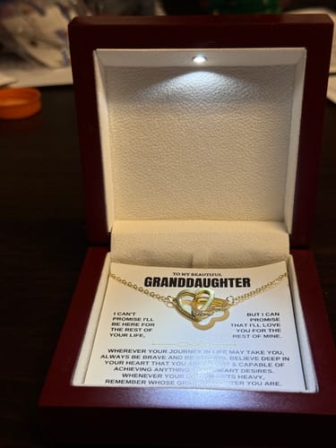 Reviewer showing the Replacement Attachment necklace with interlocking hearts inside its lighted, dark red gift box for a granddaughter.