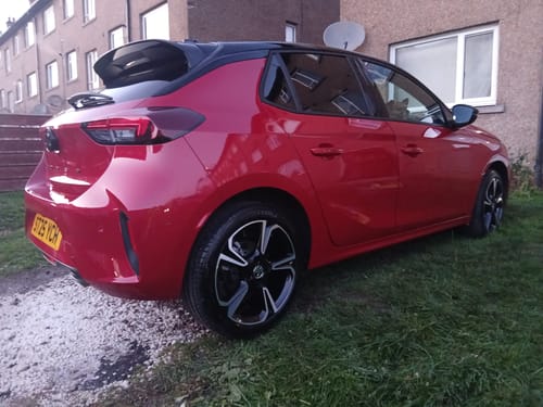 Customer's shiny red car, showing the glossy finish from the Mystery Box products on the rear and side.