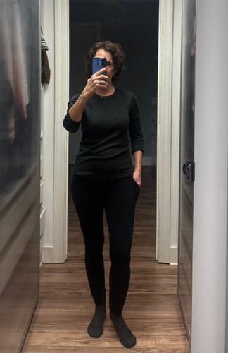 Reviewer showing the fit of the black Piper Pocket Leggings with a hand in the pocket.