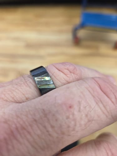 Reviewer's hand wearing The Mariner ring, showing the dark band with an iridescent inlay.